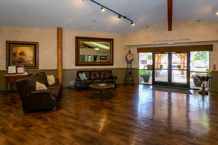 Spacious lobby area with comfortable seating and wooden flooring.