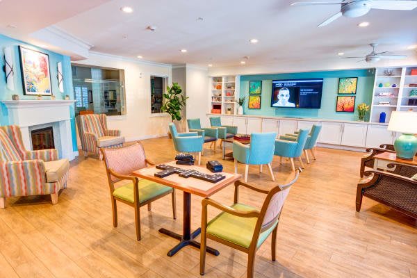 A modern seating area with colorful chairs and tables in a community lounge.