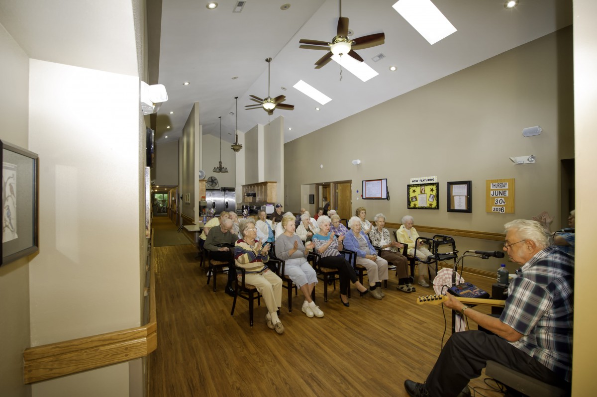 A group of seniors seated indoors, attending a community event.