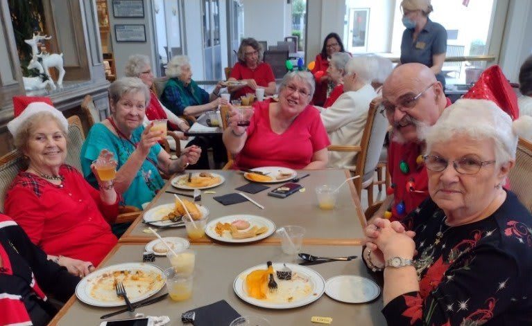 A lively group of elderly people enjoying a meal together at a social gathering.