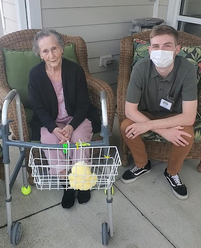 An elderly woman and her caregiver enjoying time together outdoors.