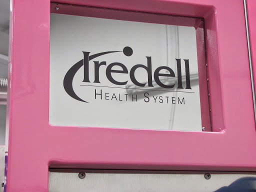 Sign of Iredell Health System displayed on a pink background.