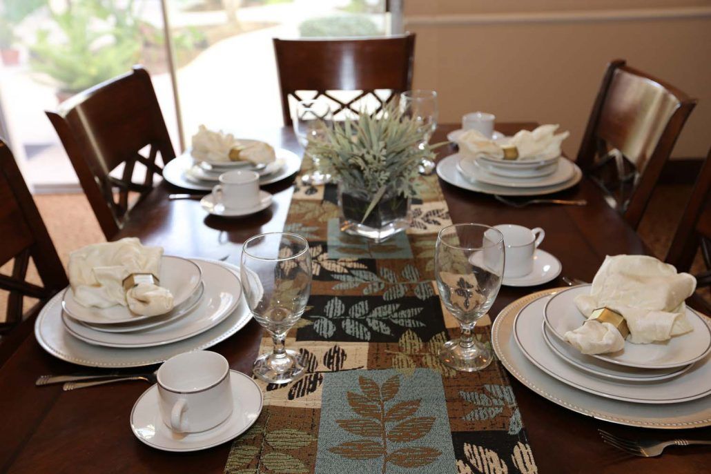 A neatly arranged dining table with elegant place settings and a decorative centerpiece.