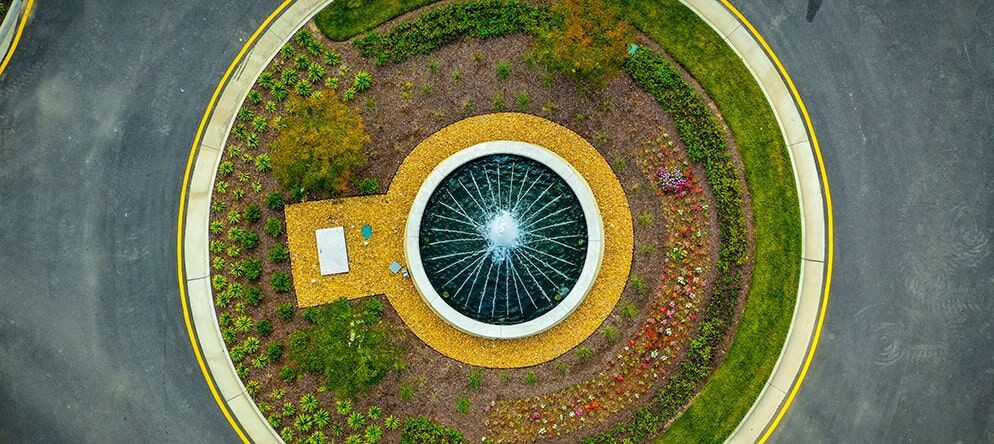 Aerial view of a beautifully landscaped garden featuring a circular fountain.