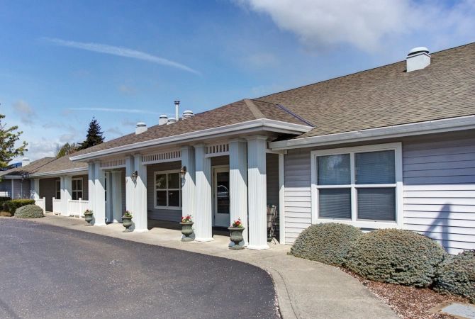 A front view of a building with a driveway and clear blue sky.