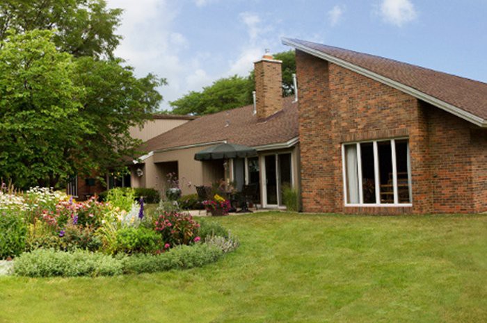 A modern brick house with a well-maintained garden and lawn.