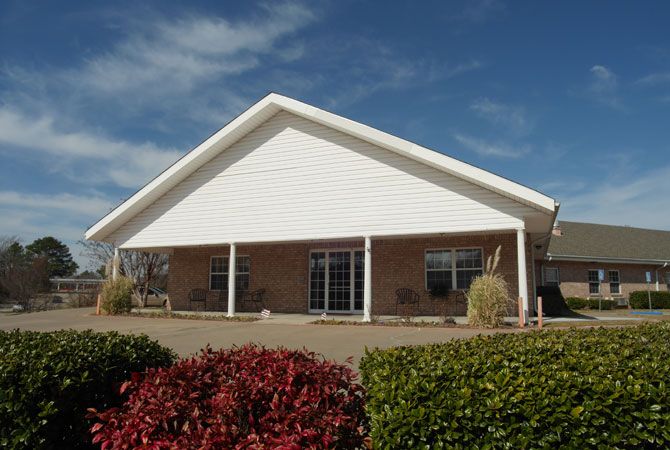 A single-story house with a large covered porch and landscaped front yard.