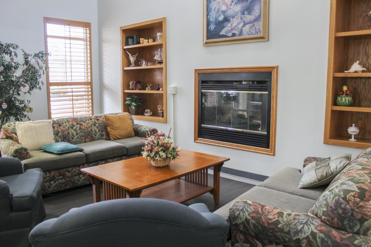 A cozy living room with sofas, a coffee table, and a fireplace.