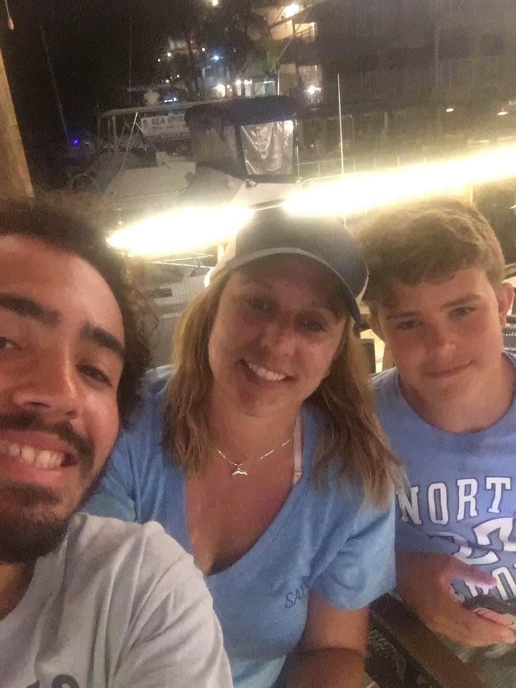 A happy group of three people smiling together in a casual setting.