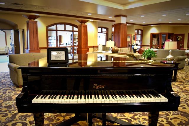 A grand piano in a luxurious hotel lobby setting.
