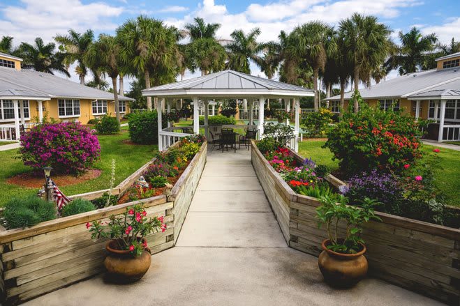 A picturesque garden scene featuring a gazebo surrounded by vibrant flowers and lush greenery.