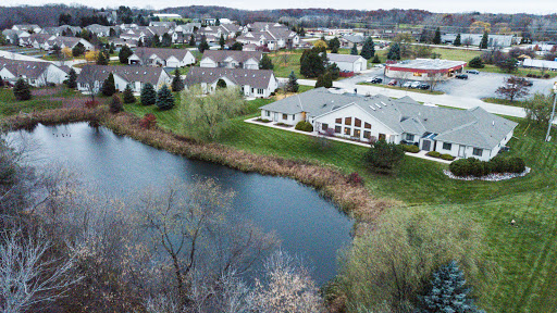 A serene aerial view of a suburban neighborhood beside a tranquil pond.