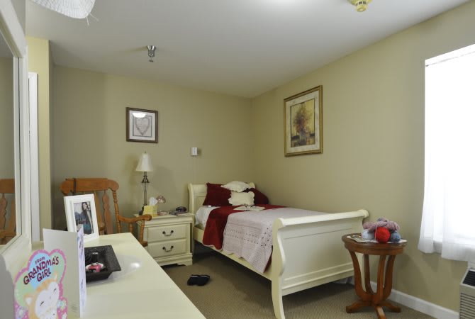 A cozy bedroom with a single bed, nightstand, and wall decorations.