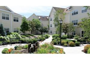 A well-landscaped apartment complex featuring a curving pathway and lush greenery.