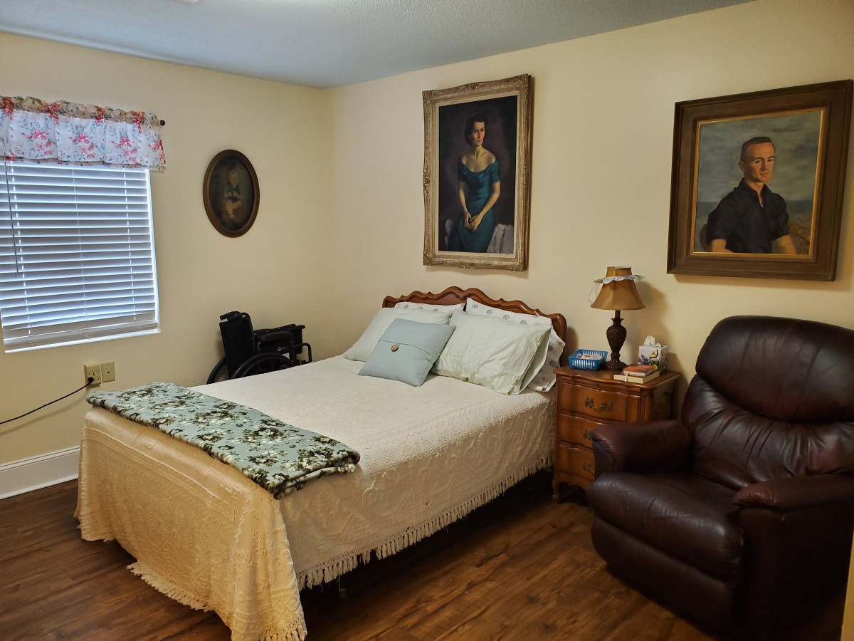 Cozy bedroom with classic decor and paintings on the walls.