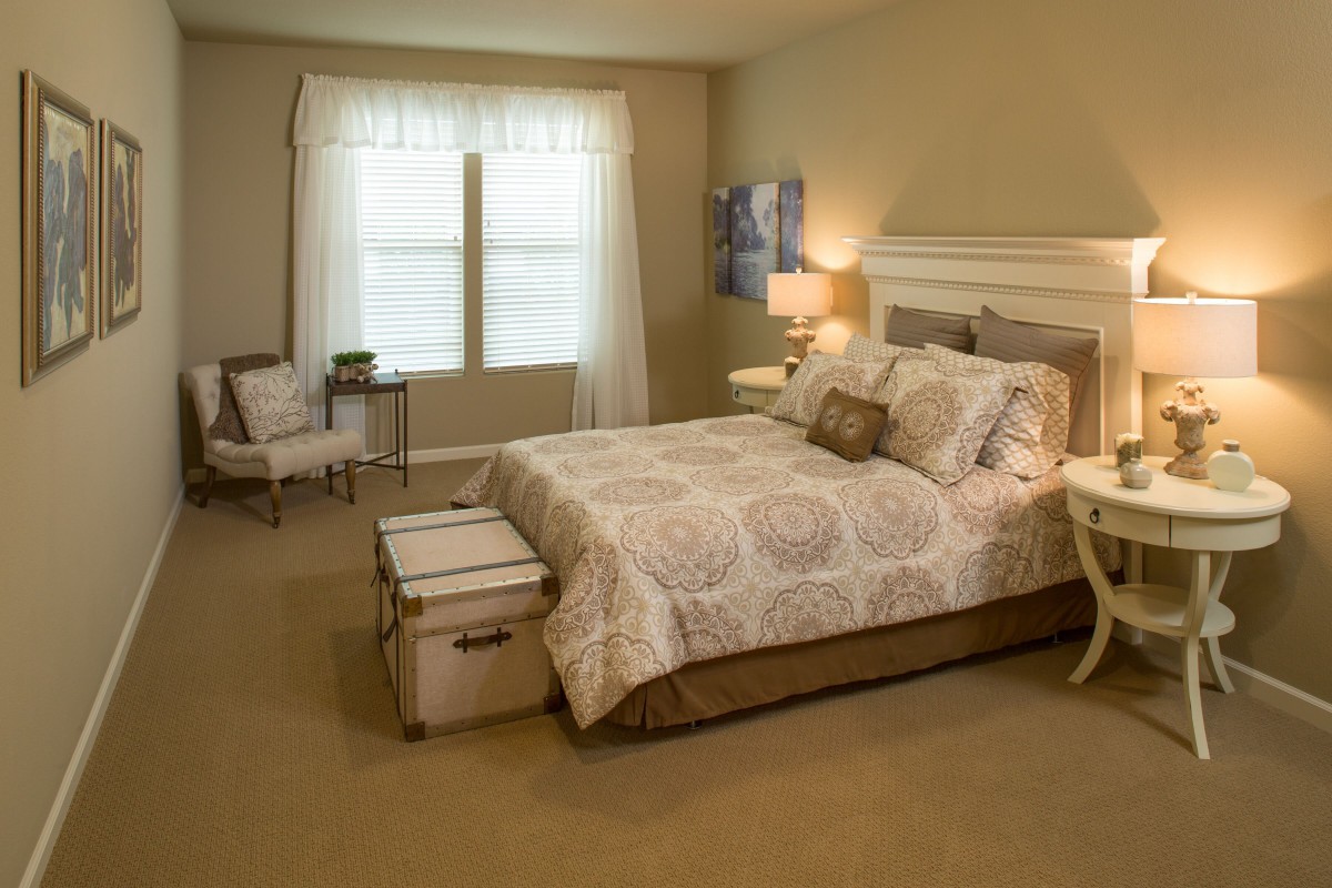 A cozy and elegantly decorated bedroom with soft lighting and neutral tones.