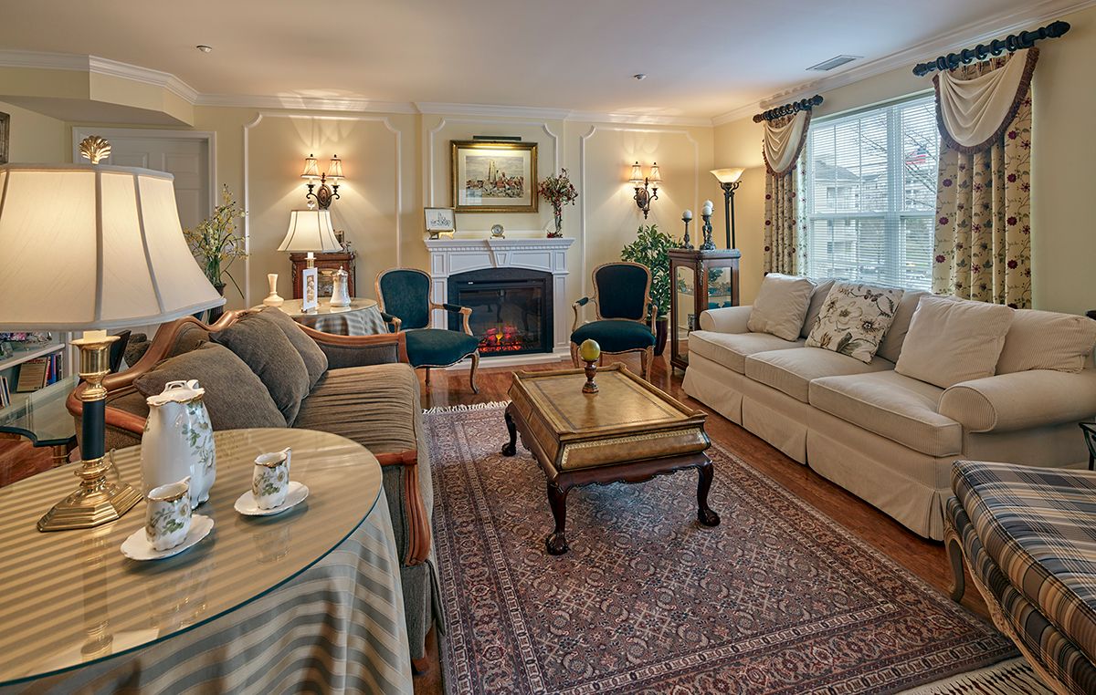 A classic living room interior with sofas, a central table, and a fireplace.
