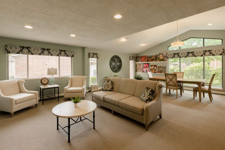 A stylish open-concept living room with neutral tones, featuring a comfortable sofa and adjacent dining area.
