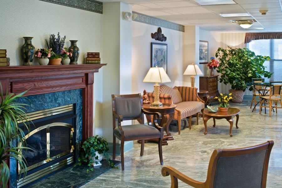 A cozy living room with a classic fireplace, comfortable seating, and elegant decor.