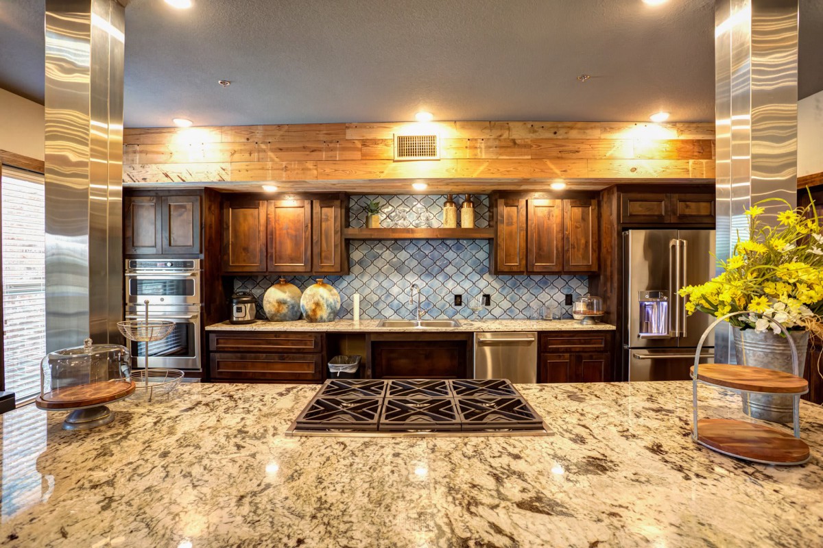 A modern kitchen featuring wood cabinetry and a granite countertop.