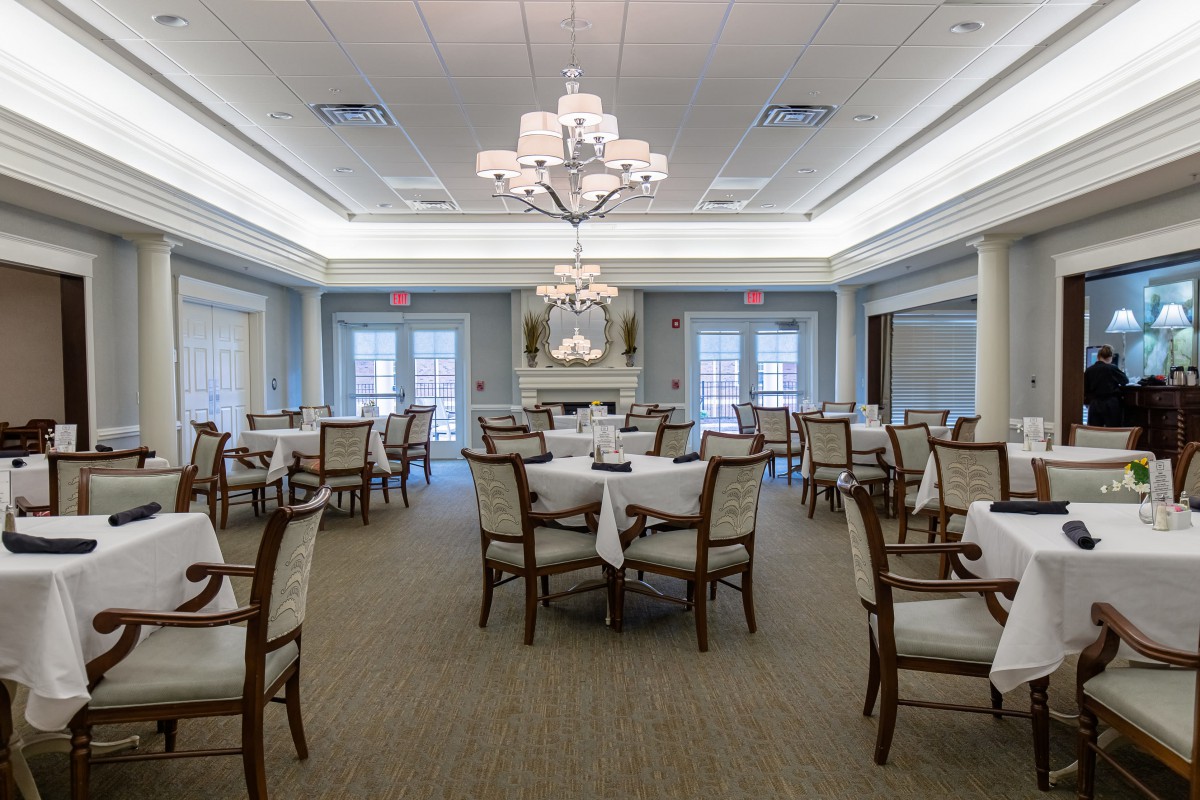 Elegant dining room with neatly arranged tables and chandeliers.