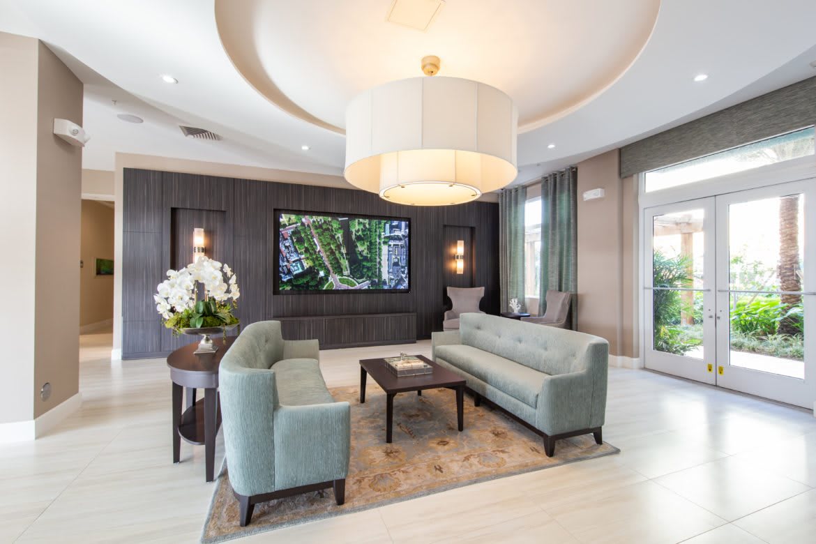 A modern living room with elegant decor, featuring a large chandelier, comfortable sofas, and tasteful wall art.