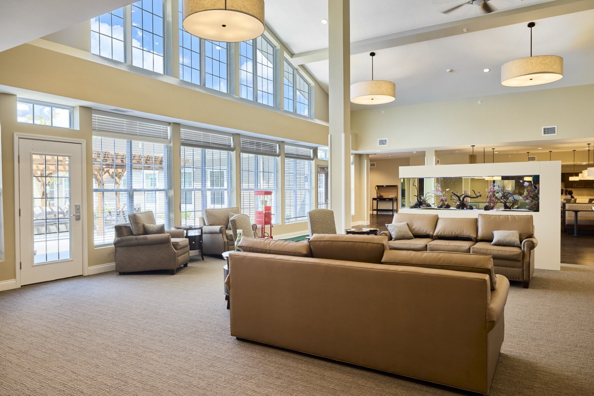 A spacious and modern living room with large windows and comfortable seating.