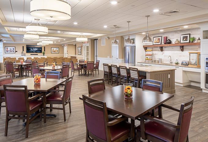 A modern dining area with tables, chairs, and a bar counter.