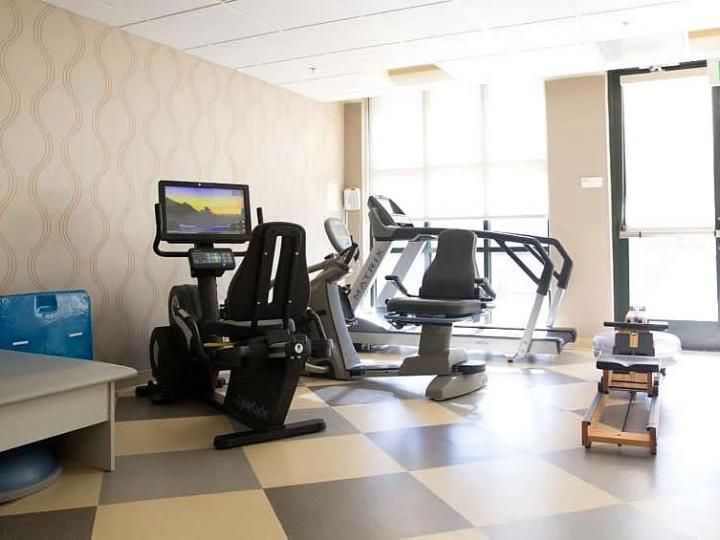A modern gym with various exercise machines including treadmills and stationary bikes.