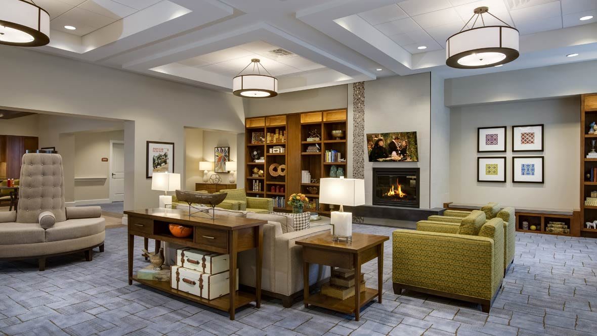 A cozy living room with a sofa, bookshelves, and a fireplace.