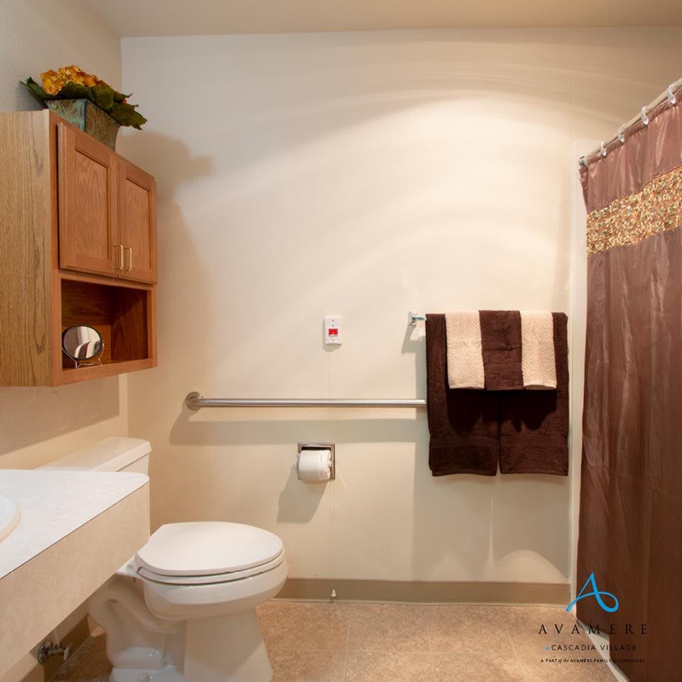 A well-organized bathroom with a toilet, sink, shower curtain, and towels.