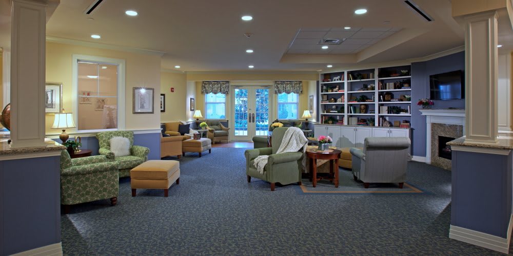 A cozy seating area with comfortable chairs and bookshelves in a well-lit room.