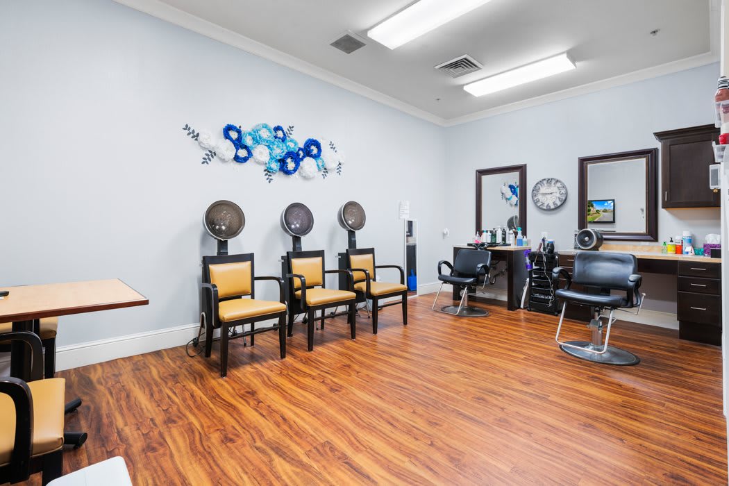 A modern hair salon interior featuring chairs, hair dryers, and stylish decor.