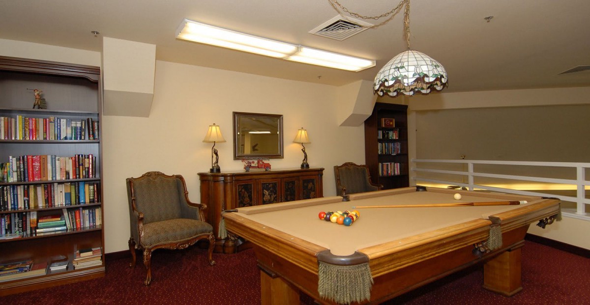A cozy billiard room with a pool table and elegant furnishings.