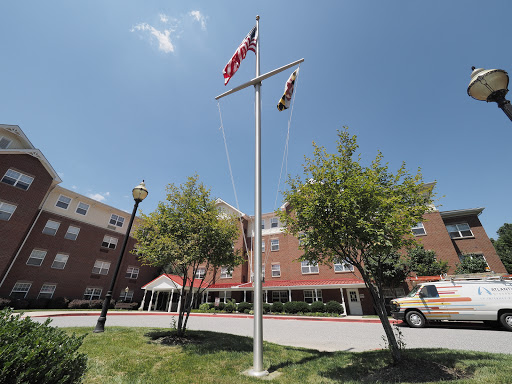 Flags flying in front of a building under a clear blue sky.