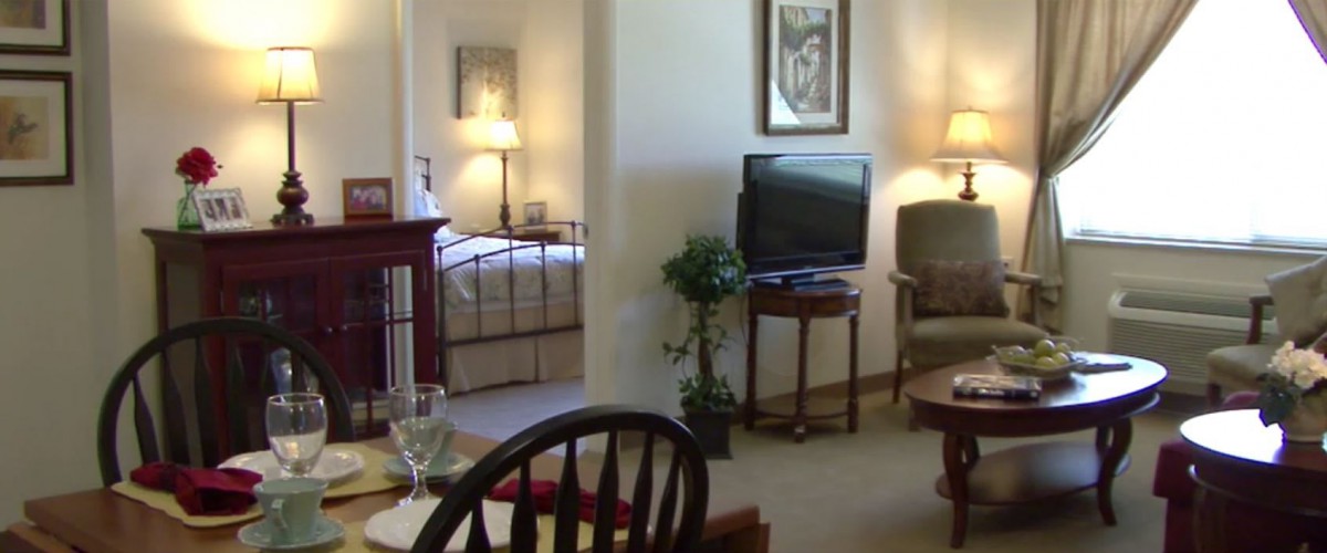 A cozy interior featuring a living room and adjacent bedroom with comfortable furniture and warm lighting.