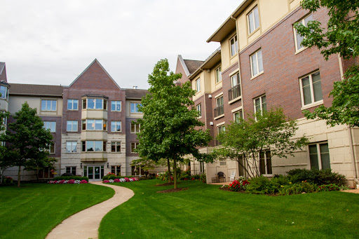 A beautifully landscaped residential building with lush green lawns and trees.