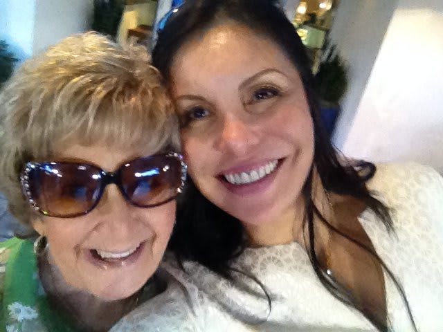 A cheerful selfie of two women smiling together indoors.