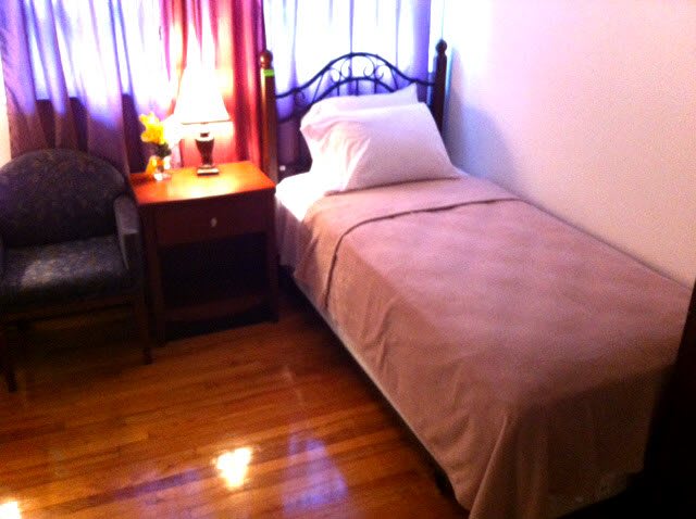 A cozy bedroom with a single bed and nightstand.