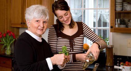 Two women enjoying cooking together in the kitchen.