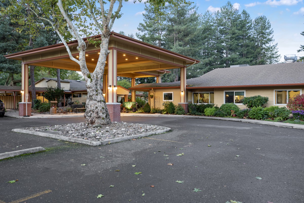 A welcoming entrance with a covered walkway surrounded by lush greenery.