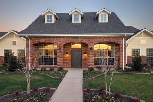 A beautiful brick house with well-maintained landscaping and a welcoming front porch.