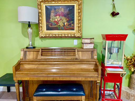 A beautifully arranged corner featuring a wooden piano, a decorative lamp, and an artwork on a vibrant green wall.