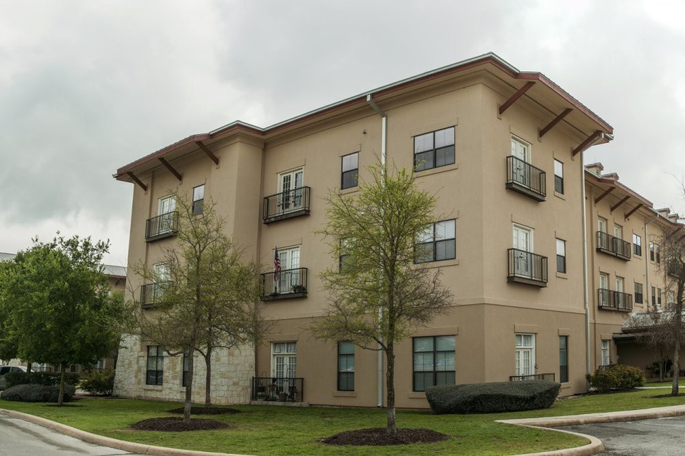 A modern apartment building with balconies and well-maintained landscaping.