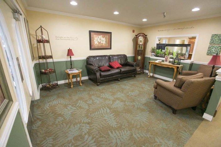 A cozy living room with a sofa, grandfather clock, and decorative elements.