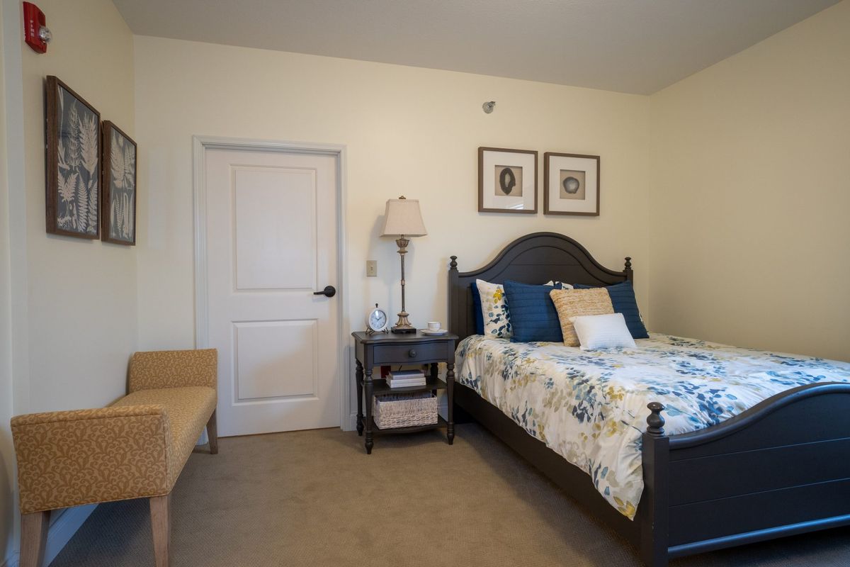 A cozy bedroom with a bed, nightstand, and decorative elements.