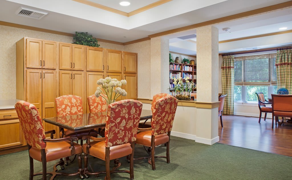 A dining room with a wooden table and patterned chairs, set within a well-decorated interior.