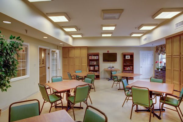 A meeting room with tables and chairs arranged neatly.