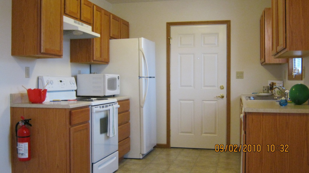 A tidy kitchen with wooden cabinets, a white refrigerator, and appliances.