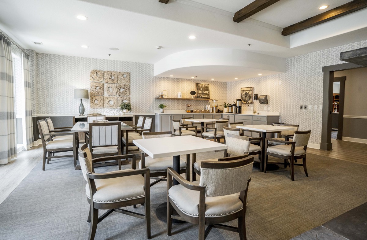 A modern dining area with stylish tables and chairs, featuring neutral tones and elegant decor.